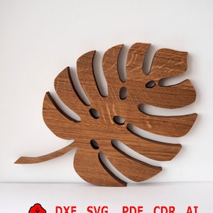 Könnte beinhalten: Ein Holzschnitt eines Monstera-Blattes in brauner Farbe. Das Blatt ist eine beliebte tropische Pflanze und wird oft in der Inneneinrichtung verwendet. Das Bild enthält den Text "DXF SVG PDF CDR AI".