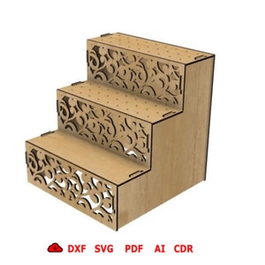 May include: A three-tiered wooden display stand with decorative cut-out floral patterns on the front panels. The stand is made of light-colored wood and has a stepped design. The bottom of the image includes the text "DXF SVG PDF AI CDR".