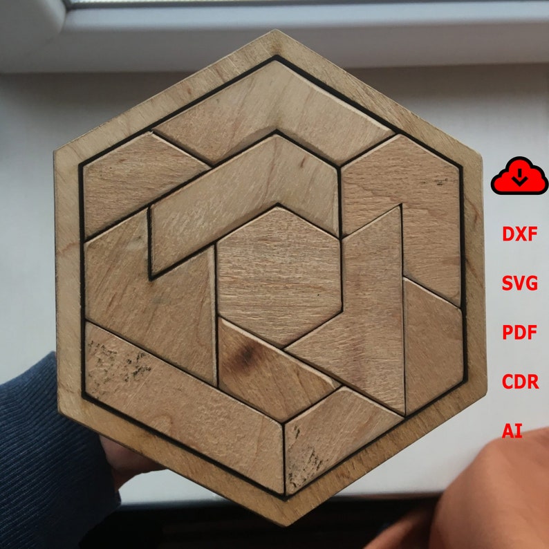 May include: A hexagonal wooden puzzle with a geometric design. The puzzle is made of multiple pieces that fit together to create a complex pattern.