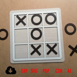 Op de afbeelding: Een houten tic-tac-toe-spelbord met zwarte X- en O-stukken. Het bord is gemaakt van licht hout met een witte rand. De stukken zijn gerangschikt in een winnend patroon voor de O-speler. Het spel is klaar om te spelen.