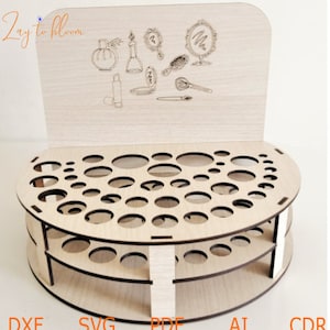 Pu&ograve; includere: Organizzatore per trucco in legno con base circolare e tre livelli di fori rotondi. L'organizzatore ha un pannello posteriore con un design decorativo di pennelli per il trucco, bottiglie e specchi. Il testo "Zay to bloom" &egrave; stampato sul pannello posteriore.
