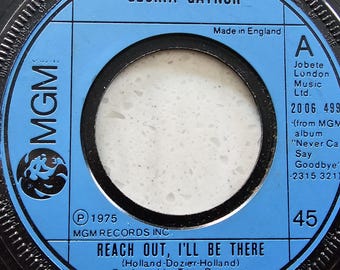 May include: A 45 RPM record label for Gloria Gaynor's song "Reach Out, I'll Be There." The label is blue with black text and a white center. The record was made in England and released in 1975.