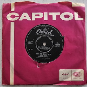 Könnte beinhalten: Eine Vintage-Vinyl-Schallplatte für "Ode to Billy Joe" von Bobbie Gentry, in einer rosa Capitol Records-Hülle. Das Schallplattenetikett ist schwarz mit weißem Text, und die Hülle zeigt das Capitol Records-Logo.