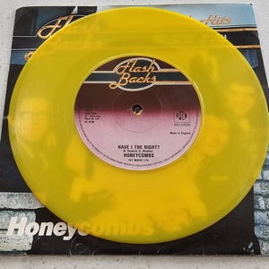 Può includere: Un disco in vinile a 45 giri di colore giallo traslucido con il brano Have I the Right dei The Honeycombs. L'etichetta centrale è marrone con testo dorato, che mostra il logo Flash Backs, il marchio Pye Records e l'anno 1964 su una custodia.