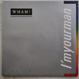 May include: A silver record album cover with the text "WHAM!" in black letters at the top and "I'm Your Man" in white letters on the right side. The album number "A 6 7 1 6" is printed in black at the bottom.