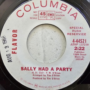 以下が含まれることがあります： 赤色の「COLUMBIA」の文字が入った白いラベルのヴィンテージレコード。レコードのタイトルは「SALLY HAD A PARTY」で、「AUG 1 3 1968」の日付が入っています。ラベルには「45 RPM」と「RADIO STATION COPY」も記載されています。