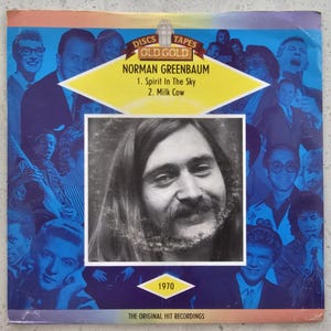 May include: A vintage album cover for Norman Greenbaum's "Spirit in the Sky" and "Milk Cow" from 1970. The cover features a portrait of Greenbaum, with a blue and gold background with other musicians. The text "Old Gold" is at the top.