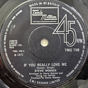 May include: A black vinyl record with the song "If You Really Love Me" by Stevie Wonder. The label features the Tamla Motown logo, the text "Made in Gt. Britain," and the speed "45 RPM."