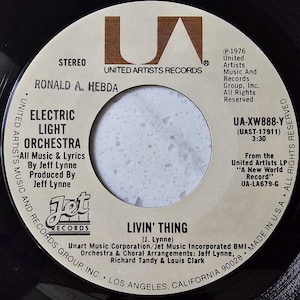 May include: A vintage vinyl record for the Electric Light Orchestra's song "Livin' Thing." The record label is cream-colored with black text, featuring the United Artists Records logo and the Jet Records logo. The record was made in the U.S.A.