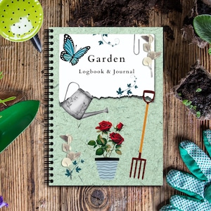 May include: A spiral-bound garden logbook and journal with a light green cover. The cover features illustrations of a butterfly, watering can, roses, and a garden fork. The text "Garden Logbook & Journal" is printed on the cover.