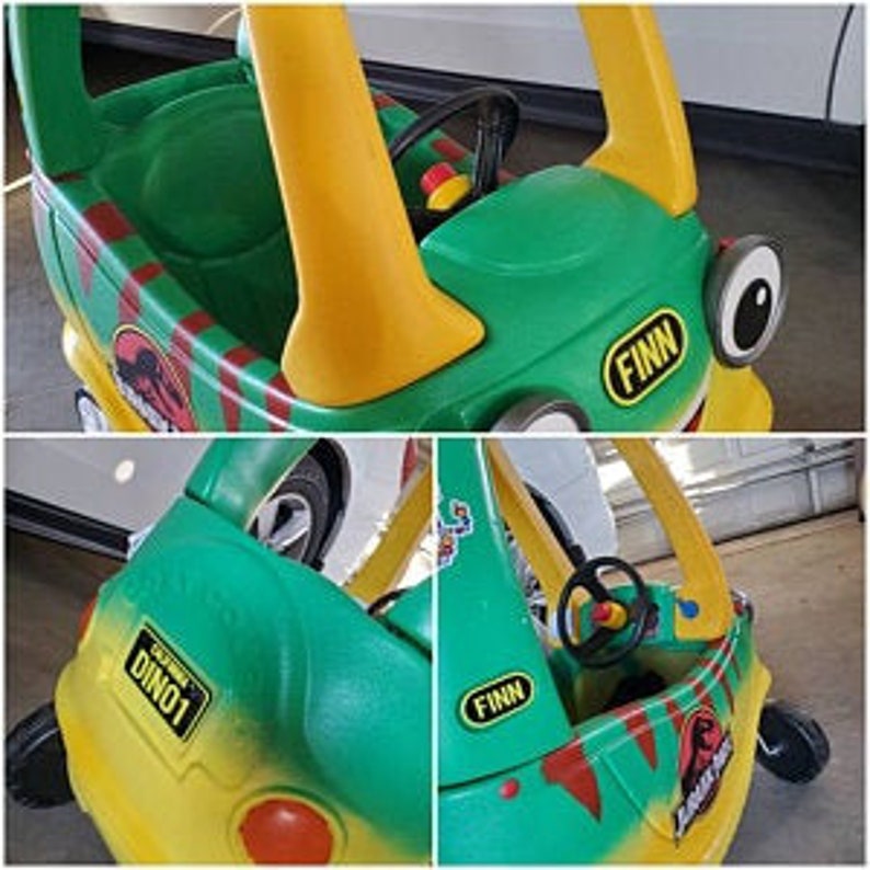 Puede incluir: Coche de juguete de pl&aacute;stico verde y amarillo con volante, una pegatina de dinosaurio y el nombre "FINN" en el lateral. El coche tiene un dise&ntilde;o de rayas rojas y amarillas.