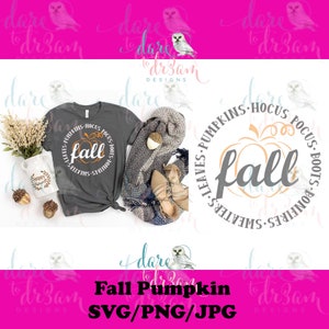 May include: A gray t-shirt with a round design featuring the word "fall" in a gray font with a pumpkin graphic. The design also includes the text "Leaves, Pumpkins, Hocus Pocus, Boots, Bonfires, Sweaters".