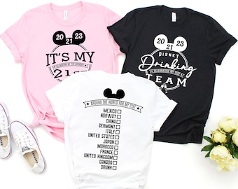 May include: Three t-shirts with a Disney theme. The pink shirt says "It's My 21st", the black shirt says "Disney Drinking Team", and the white shirt says "Around the World for My 21st" with a checklist of countries.