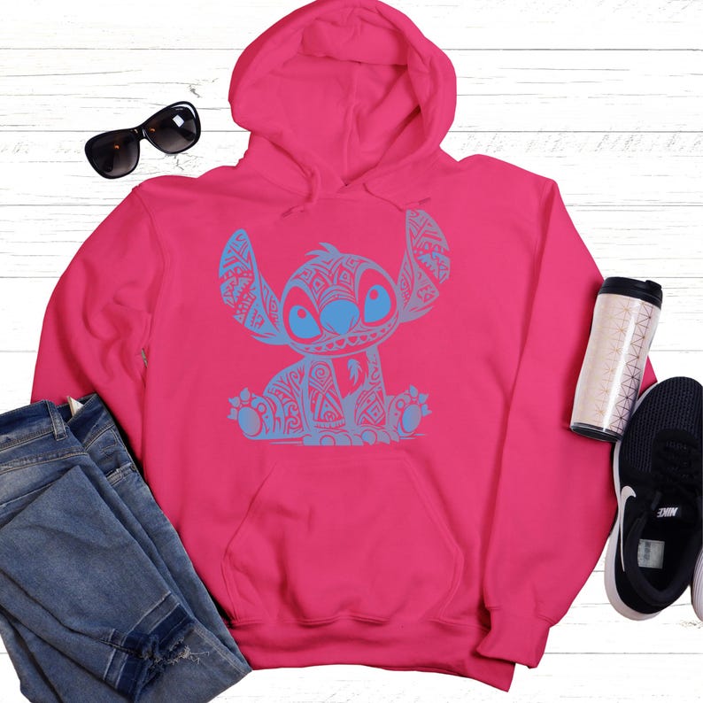 K&ouml;nnte beinhalten: Ein rosa Hoodie mit einem blauen und wei&szlig;en Stitch-Muster auf der Vorderseite.