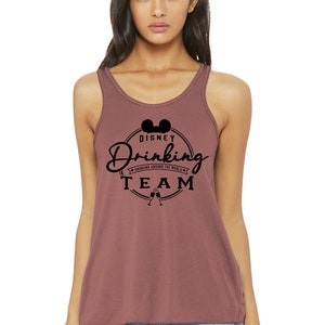 Może przedstawiać: Bordowy top na ramiączkach z czarnym nadrukiem uszu Myszki Miki i tekstem "Disney Drinking Team" z mniejszym tekstem "Drinking Around the World" poniżej.