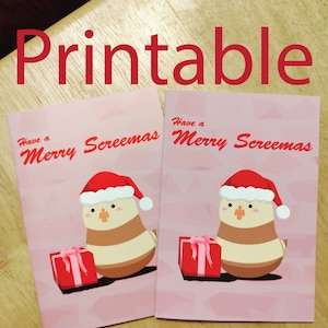 May include: Two printable greeting cards with a pink background. Each card features a cartoon bird wearing a Santa hat and holding a red gift box. The text on the cards reads "Have a Merry Screemas".