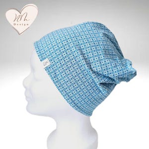 Könnte beinhalten: Eine blaue und weiße gemusterte Mütze mit einem kleinen weißen Etikett, auf dem "Mh Design" steht.
