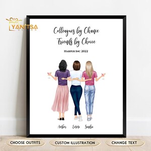 May include: A framed print featuring an illustration of three women with their arms around each other. The women are dressed in casual attire and holding drinks. The text "Colleagues by Chance, Friends by Choice" is displayed above the illustration, with the names Amber, Emma, and Sandra below.