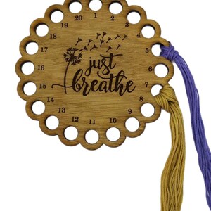 Thread holder in a flower shape with "Just Breathe" engraved, featuring 20 holes for thread.