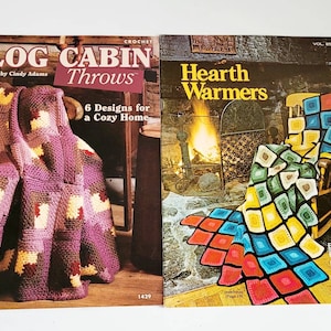 Puede incluir: Dos libros de patrones de ganchillo, uno titulado "Log Cabin Throws" con una manta de ganchillo morada y marrón en una mecedora, y el otro titulado "Hearth Warmers" con una manta de ganchillo colorida en una mecedora frente a una chimenea.