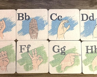 May include: Eight square cards with the letters of the alphabet A through H in black text. Each card has a different hand sign for the corresponding letter in American Sign Language. The cards have a blue and green watercolor background.