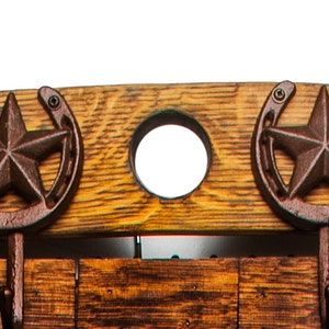 Pu&ograve; includere: Un appendiabiti in legno rustico con cinque ganci, con un design a forma di ferro di cavallo e stella. L'appendiabiti &egrave; realizzato in legno riciclato e ha una finitura naturale. &Egrave; decorato con corda e dettagli in metallo.