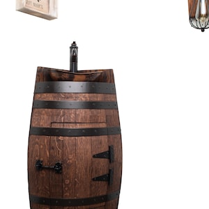 May include: A wooden barrel sink vanity with a black faucet and a small, round, wooden sink. The barrel has a wooden door with black hinges and a black handle. The barrel is sitting on a white background.