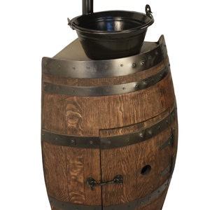 May include: A wooden barrel vanity with a black metal sink and faucet. The vanity has a cabinet door with a metal latch.