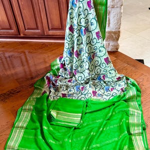 Mysore silk saree with digital printed florals. The border is parrot green in color.  Body has mint color base.Comes with unstitched blouse.