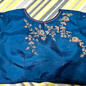 Teal blue silk blouse with handwork on the front and back. Size 38.