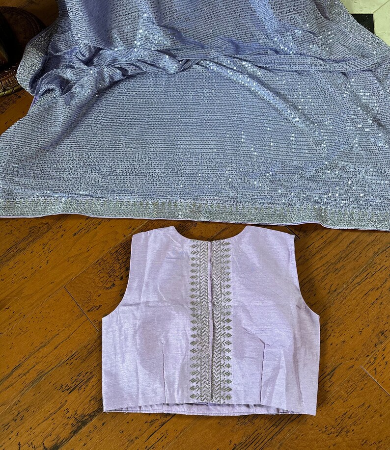 Pode incluir: Uma blusa sem mangas lavanda com um design bordado em prata nas costas.