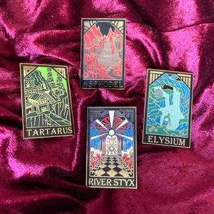 May include: Four rectangular enamel pins with gold borders. Each pin features a different illustrated scene with text: "TARTARUS", "ASPHODEL", "ELYSIUM", and "RIVER STYX". The pins are set against a deep red velvet background.