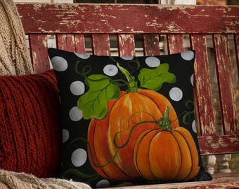 Dos calabazas naranjas con lunares blancos impresas a partir de un diseño original pintado a mano sobre una almohada de primera calidad. Doble cara e incluye relleno.