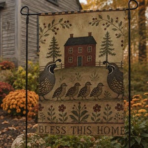 May include: A rectangular garden flag featuring a printed illustration of a red house, two adult quail, and four chicks. The design includes green pine trees, floral motifs, and the text BLESS THIS HOME in a dark font on a cream-colored background.