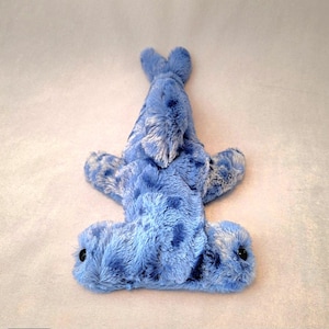 Pu&ograve; includere: Un giocattolo di peluche a forma di squalo martello blu con occhi neri. Il giocattolo &egrave; realizzato in materiale morbido e soffice con macchie blu scuro e dettagli bianchi. Sono visibili la coda e le pinne dello squalo.