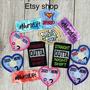 Op de afbeelding: Een assortiment geborduurde strijkpatches met verschillende ontwerpen met betrekking tot het medische beroep. De patches omvatten harten, een superheld en de tekst "#NurseLife".