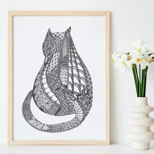 May include: Black and white cat art print in a light wood frame. The cat is depicted from the back, with intricate patterns filling its form. A white vase with white flowers is to the right of the framed art.