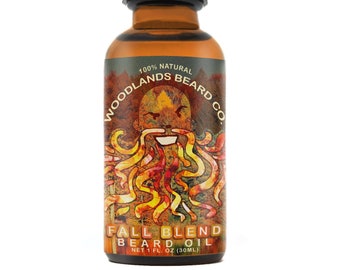 May include: A glass bottle of beard oil with a dropper top. The bottle is labeled "Woodlands Beard Co. Fall Blend Beard Oil, Net 1 fl. oz (30ml)". The label features a cartoon illustration of a bearded man with a fall-themed design.