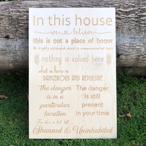 May include: A wooden sign with the text "In this house we believe this is not a place of honour. No highly esteemed deed is commemorated here. Nothing is valued here. What is here is DANGEROUS AND REPULSIVE. The danger is in a particular location. The danger is still present in your time. This place is best left Shunned & Uninhabited."