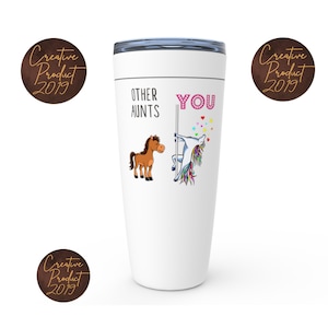 May include: White travel mug with a unicorn and a horse on it. The text on the mug reads "Other Aunts You".