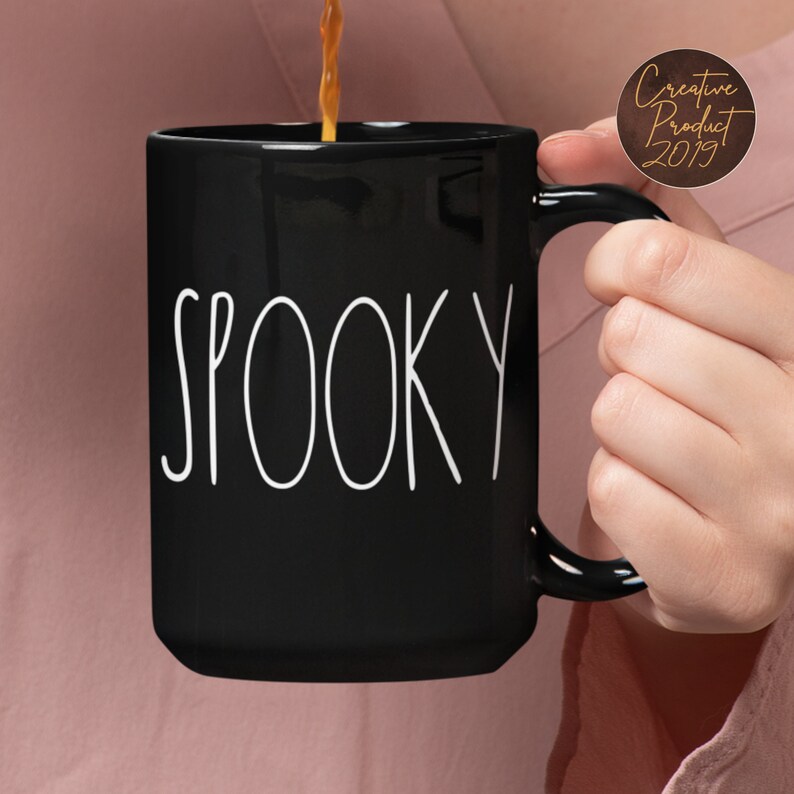 May include: Black coffee mug with white text that reads "SPOOKY".