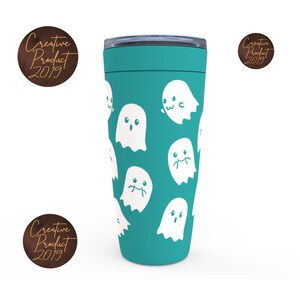 May include: A teal travel mug with a white ghost pattern. The ghosts have different facial expressions.