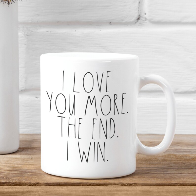 May include: White ceramic coffee mug with black text that reads "I love you more. The end. I win."