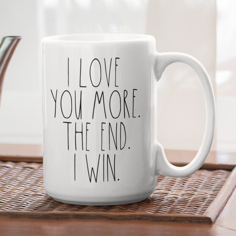 May include: White ceramic coffee mug with black text that reads "I love you more. The end. I win."