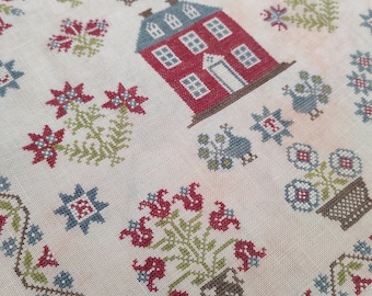 May include: A cross-stitch sampler with a red house, blue roof, and windows, encircled by floral and geometric patterns in red, blue, and green. The year "1776" is stitched above the house. The design is on a cream-coloured fabric.