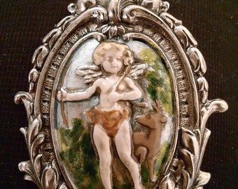 1 cupid button in painted enamels 1 and a half inch by 2 inch.