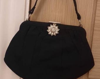 Antique art deco pouch bag in black fabric and paste stone closure detail.