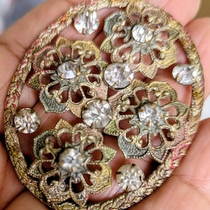 May include: A white ceramic mug with a black handle and the text "But First, Coffee" in a bold, black font. The mug is set against a blurred background, suggesting a cozy setting.