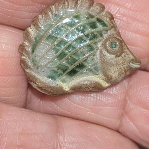 ヴィンテージの陶器製、釉薬仕上げのハリネズミ型ボタン。直径2.5cm。