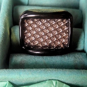 Botón estilo Bimini de rejilla oblonga en oro negro regaliz y plata. 2,4 cm por 2 cm.